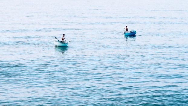 Simple background Calm dark blue sea fishing boats alone white pale Spindrift clouds Open way no limitations.