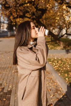 A stylish brunette woman walks around the autumn city. The season is autumn.