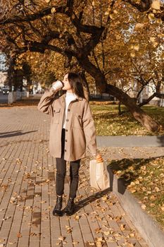 A stylish brunette woman walks around the autumn city. The season is autumn.