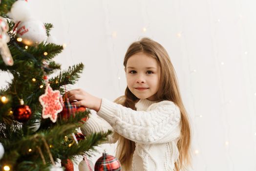 Portrait of a smiling little girl decorating the Christmas tree