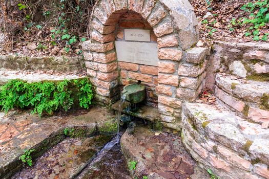 An old stone faucet with fresh water near Alagonia village in Greece.