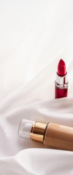 Cosmetic branding, glamour and skincare concept - Beige tonal cream bottle make-up fluid foundation base and red lipstick on silk background, cosmetics products as luxury beauty brand holiday design