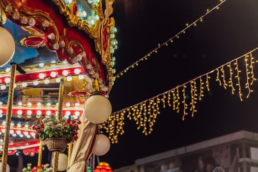 Illuminated swing chain carousel in amusement park at night.