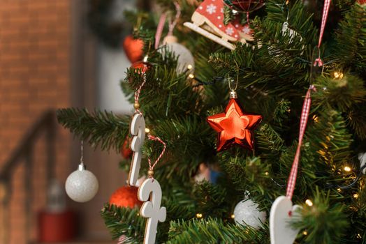 Ornament in the form of a star on the Christmas tree at home. copy space. Christmas tree at the porch of the house
