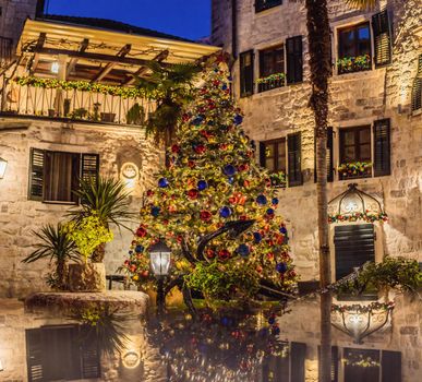 Holiday Christmas Tree Decorating with Multi Colored Lights at Night. Beautiful snowy winter scenery of Christmas holiday fair in Europe.