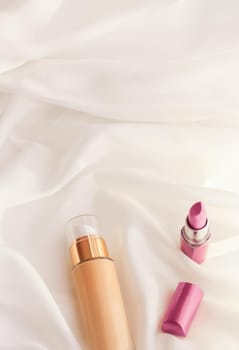 Cosmetic branding, glamour and skincare concept - Beige tonal cream bottle make-up fluid foundation base and pink lipstick on silk background, cosmetics products as luxury beauty brand holiday design