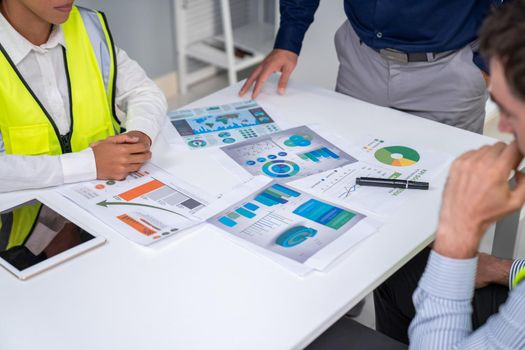 Engineers and competent employer discussing plans and blueprints together with tablet in the office. Concept of team contribution of ideas for engineering project.