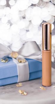 Cosmetic branding, Christmas glitter and girly blog concept - Holiday make-up foundation base, concealer and blue gift box, luxury cosmetics present and blank label products for beauty brand design