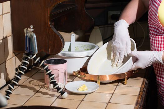 woman cooking spinach muffin step by step, mixing ingredients with mixer, recording video on mobile phone for social media, making french shirt in baking dish, greasing the mold with butter.