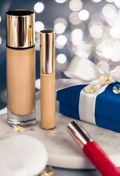 Cosmetic branding, Christmas glitter and girly blog concept - Holiday make-up foundation base, concealer and blue gift box, luxury cosmetics present and blank label products for beauty brand design