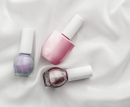 Cosmetic branding, salon and glamour concept - Nail polish bottles on silk background, french manicure products and nailpolish make-up cosmetics for luxury beauty brand and holiday flatlay art design