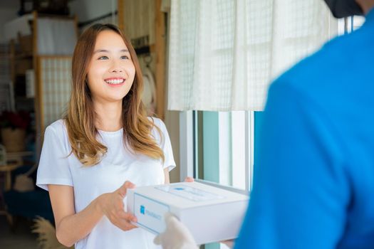 Asian woman sick she receive medication first aid pharmacy box hospital delivery service, Delivery man give medicine drug store to patient female at front home, healthcare medicine online business