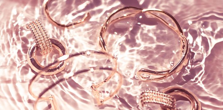 Jewellery branding, fashion gift and luxe shopping concept - Rose gold bracelets, earrings, rings, jewelery on pink water background, luxury glamour and holiday beauty design for jewelry brand ads