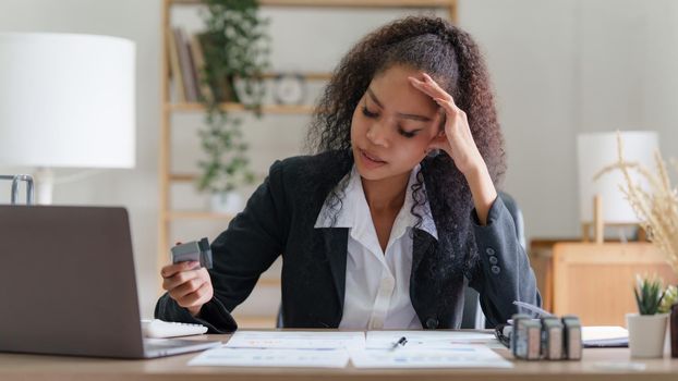 Stressed Asian business woman worry with many document on desk at office.
