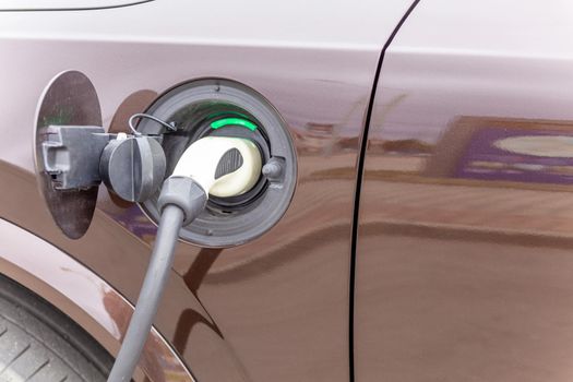 Power supply connect to electric vehicle for charge to the battery. Charging technology industry transport which are the futuristic of the Automobile. EV fuel Plug in hybrid car.