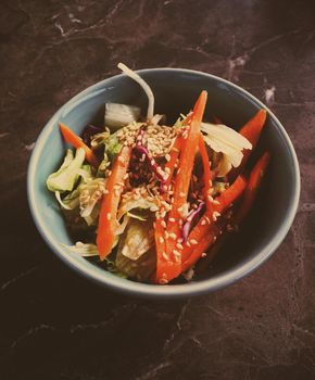 Vegan dieting, eating out and oriental cuisine concept - Vegetarian asian vegetable salad served in a bowl in japanese restaurant, healthy diet food