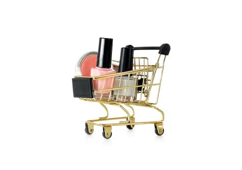 Shopping trolley full of make up and cosmetic goods, isolated on white background. Black friday concept. Sale and discount. Goods for women. Closeup of a basket with products for make-up