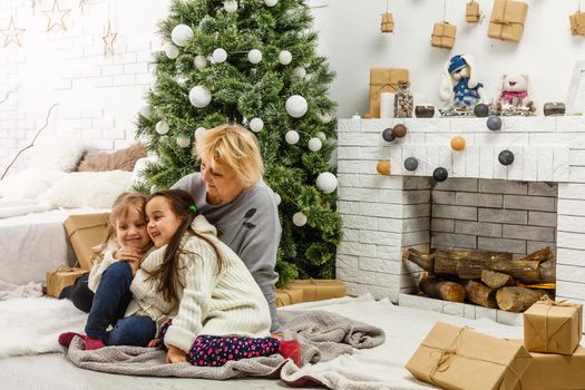 grandparents and children having fun during christmas day celebration at home with family.