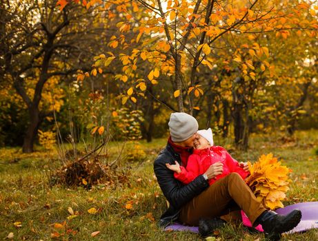 Happy family. daughter kissing and hugging her dad on a walk in the autumn leaf fall in park