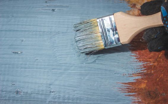 A hand with a brush that paints a tree gray. selective focus