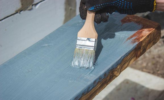 A hand with a brush that paints a tree gray. selective focus