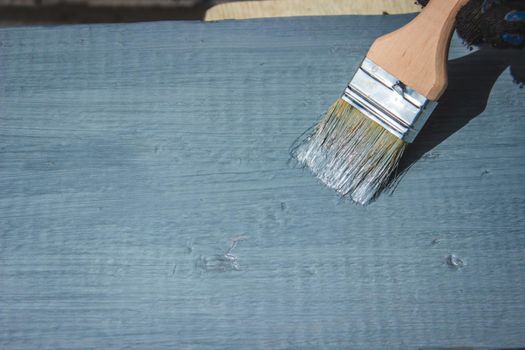 A hand with a brush that paints a tree gray. selective focus
