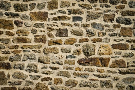 View of old wall built with stones in warm tones. Concept for backgrounds and textures.