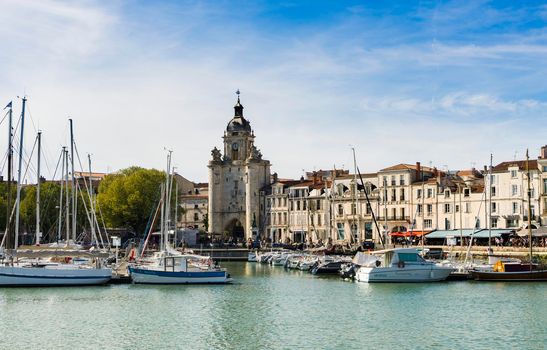 View of the old harbour of the French city of La Rochelle with blue sky and white clouds, sunny day in summer.