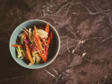 Vegan dieting, eating out and oriental cuisine concept - Vegetarian asian vegetable salad served in a bowl in japanese restaurant, healthy diet food