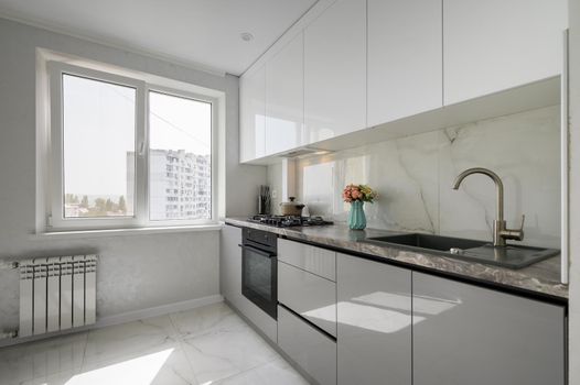 Interior of white and grey small modern domestic kitchen furniture