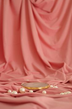 Marble podium with gold on the pink background with pearls. Podium for product, cosmetic presentation. Creative mock up. Pedestal or platform for beauty products. Minimalist design, vertical view.