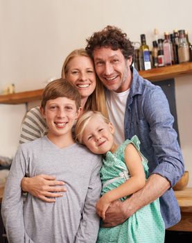 A family to be proud of. A cropped portrait of a happy family standing in their kitchen at home
