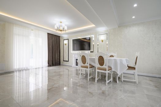 Luxurious white large home kitchen with dining table and marble floor, lots of copyspace