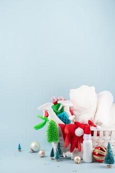Christmas cleaning. Cleaning tools and Christmas decorations in white laundry basket on blue background with copy space