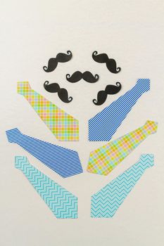 Arrangement of neckties and moustaches on white surface. Fathers day concept.