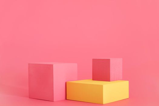 Pink and yellow podium on the pink background. Podium for product, cosmetic presentation. Creative mock up. Pedestal or platform for beauty products