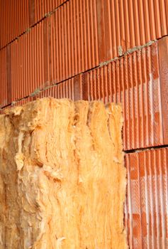 Wall of bricks and insulation wool. Building with cavity wall insulation. Close up