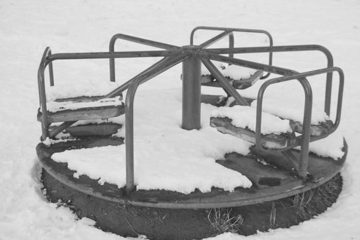 Black and white photo. Empty carousel in the snow. Epidemic