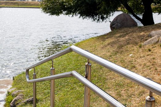 Metal railings at the stairs near the pond close up