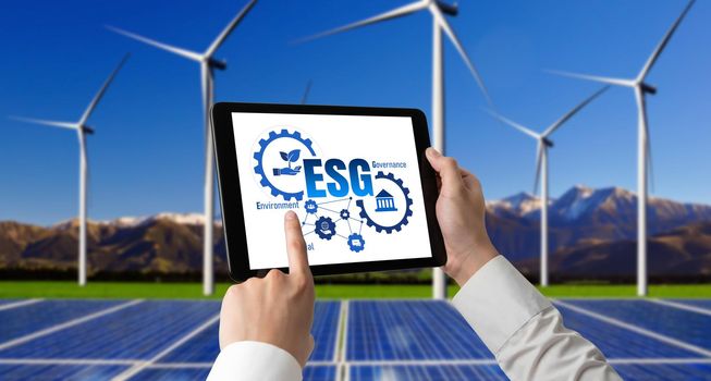 Green business transformation for environment saving and ESG business concept. Businessman using tablet to set corporate goal toward environmental friendly management and alternative clean energy use.