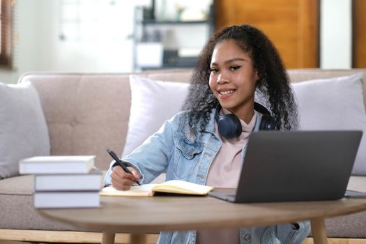 Portrait of happy female student with dark skin smiling at camera. cheerful African American hipster girl enjoying e learning and preparation to course work.