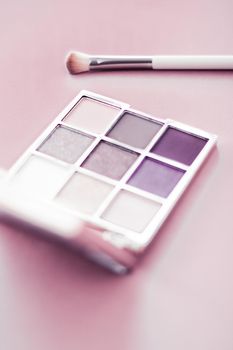 Cosmetic branding, mua and girly concept - Eyeshadow palette and make-up brush on blush pink background, eye shadows cosmetics product as luxury beauty brand promotion and holiday fashion blog design