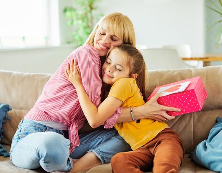 Daughter surprises her mother with present on mother's day or birthday at home