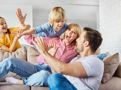 Family having fun playing on sofa at home