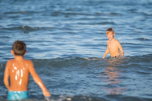 Two little boys having fun on the water, Little boys enjoying active summer, holiday in beach resort. summer concept holiday, Emilia Romagna, Italy.