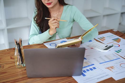Businesswoman, accountant, half girl, using notebooks and computers to monitor taxes and budget for internal company spending.
