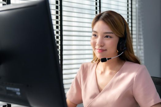 Competent female operator working on computer and while talking with clients. Concept relevant to both call centers and customer service offices.