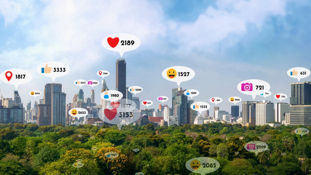 Social media icons fly over city downtown showing people reciprocity connection through social network application platform . Concept for online community and social media marketing strategy .