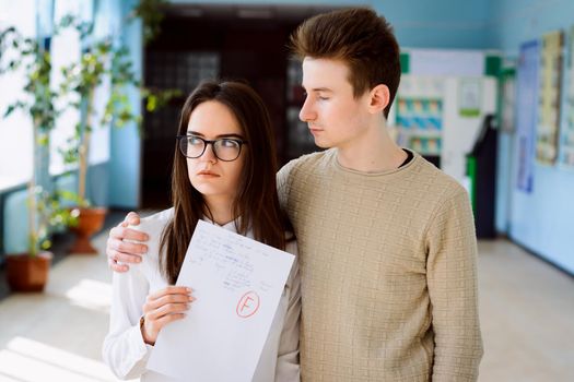 Female student failed important examination and her friend supports her, hugs her and calms her down