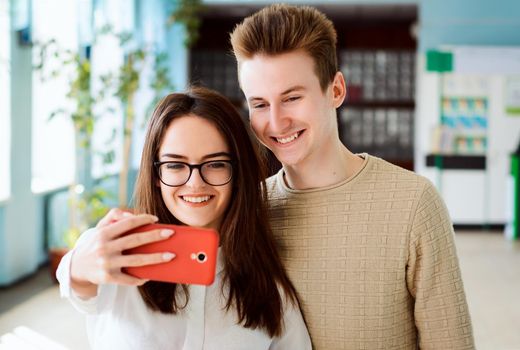 Portrait of a pair of university students taking pictures of themselves after classes